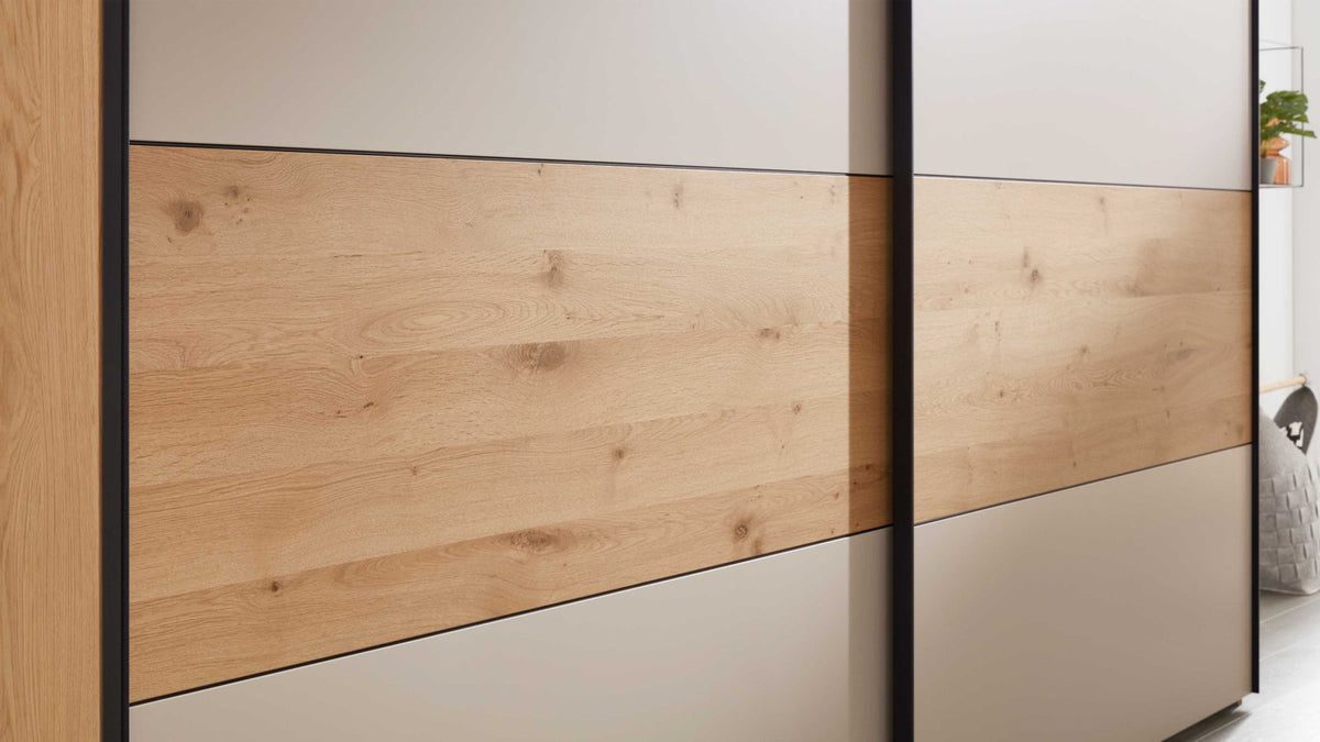 Schlafzimmer mit Schwebetürenschrank und Bett in Balkeneiche und Sand