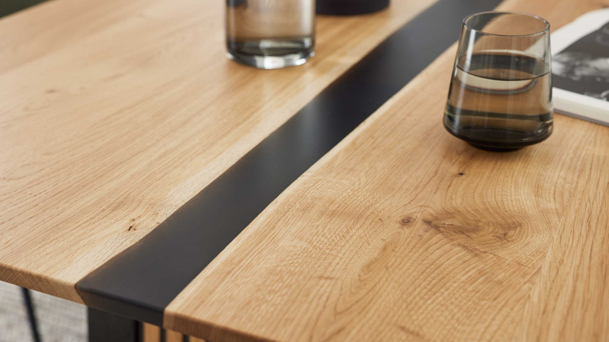 Moderner Esstisch mit massiver Holzplatte und markantem Metallgestell in Schwarz