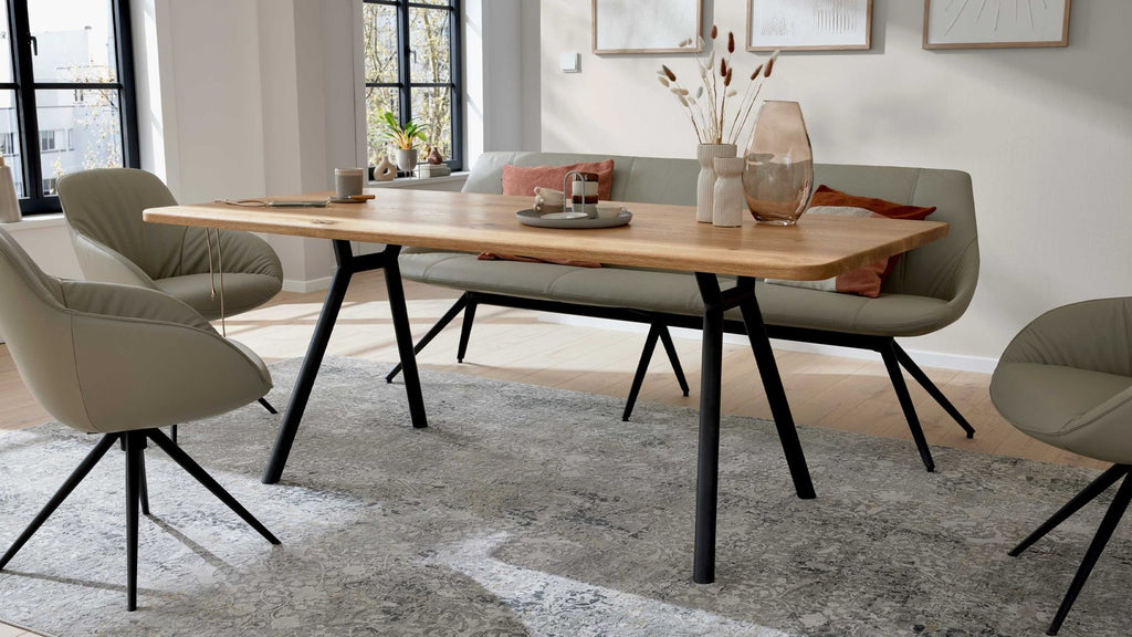 Esstisch mit massiver Holzplatte und schräg gestellten Metallbeinen