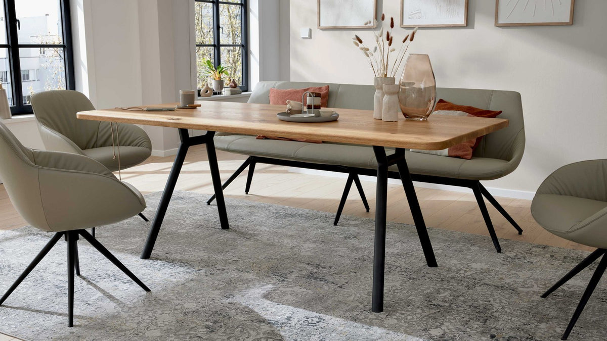 Esstisch mit massiver Holzplatte und schräg gestellten Metallbeinen