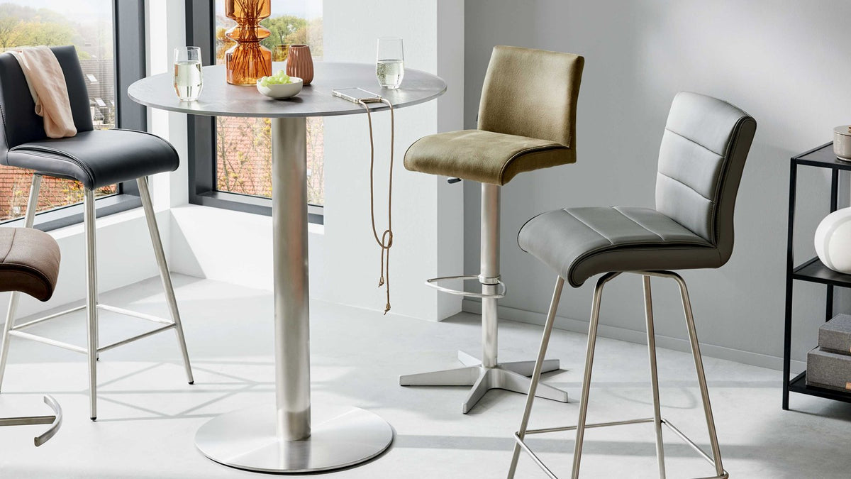 Bartisch mit runder, dunkelgrauer Platte und modernem Edelstahlgestell