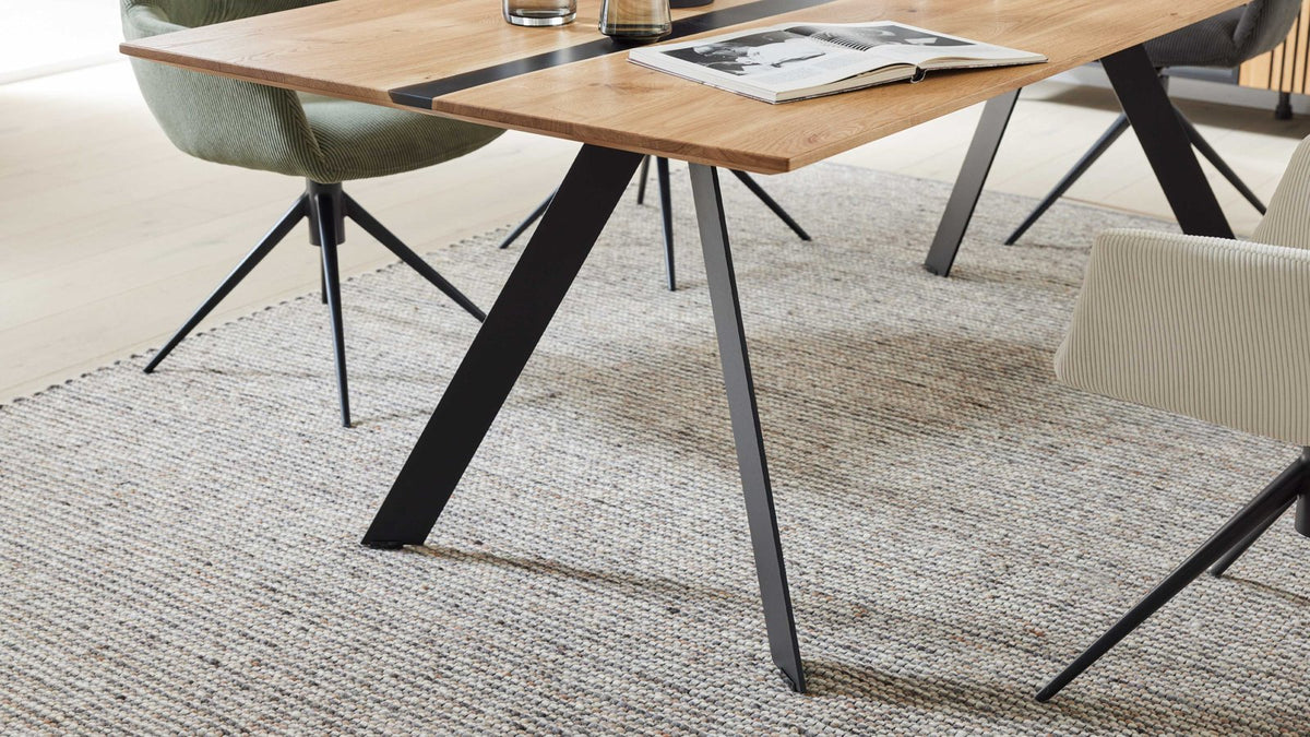 Moderner Esstisch mit massiver Holzplatte und markantem Metallgestell in Schwarz