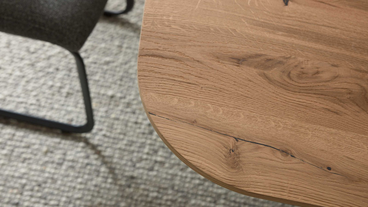 Moderner Esstisch mit abgerundeter Holzplatte und schwarzem Design-Untergestell