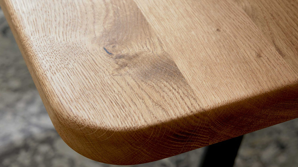 Esstisch mit massiver Holzplatte und schräg gestellten Metallbeinen